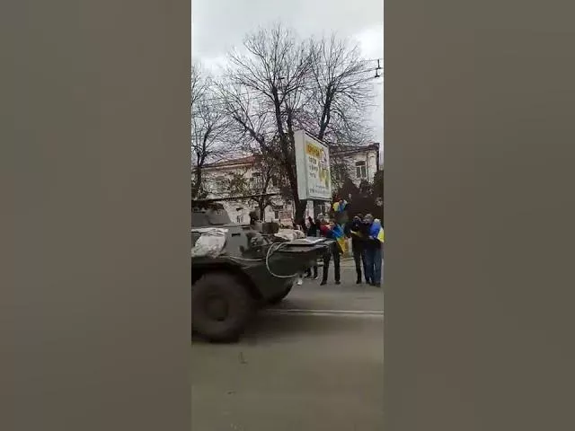 В оккупированном Херсоне человек с украинским флагом залез на росcийский БТР оккупантов.