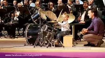 Dreijähriger dirigiert mit Schlagzeug ein Orchester